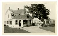 [Group in front of a house near a lake] [graphic].