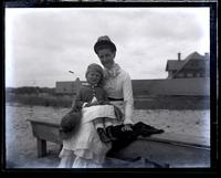 Miss Baker & her little nephew Eustace Thomson on seat near boardwalk, [Sea Girt, NJ] [graphic].