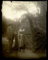 Elliston P. and Martha Morris with dog [Jet] near a gate of a wood fence, [possibly Sea Girt, NJ] [graphic].