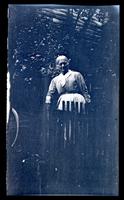 [Woman by picket fence] [graphic].