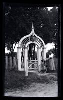 [Woman with bicycle at entrance gate, Sea Girt] [graphic].