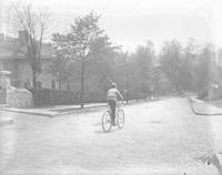 [Frank W. Berry riding bicycle downhill on cobblestone street, Manayunk] [graphic].