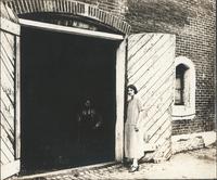 [Unidentified man and woman standing near large doorway] [graphic].