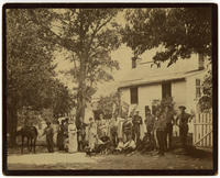 [Group portrait in front of the rear of a frame residence at an unidentified location.]
