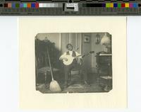 [African American youth playing banjo.]