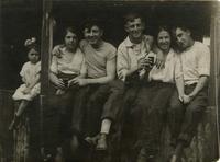 Group of young men and women sitting on a loading dock or wharf, drinking, Philadelphia.