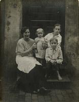 Woman and three children sitting on a wooden stoop, Philadelphia.
