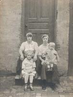 Two young women and two young children sitting on wooden steps, Philadelphia.