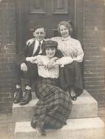 Two young women and young man on stoop, Philadelphia.