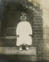 Small child standing on doorstep, Philadelphia.