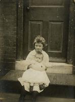 Girl with infant on lap sitting on wooden stoop, Philadelphia.