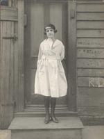 Young woman standing on stoop in front of door, Philadelphia.