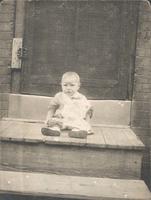 Small child sitting on wooden stoop, Philadelphia.