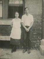 Man and woman standing in front of a brick house, Philadelphia.