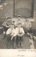 Five boys sitting on the wooden door of a sidewalk cellar entrance, Philadelphia.