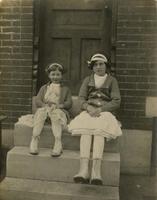Two girls wearing headbands sitting on marble steps, Philadelphia.