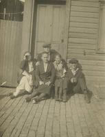 Men and women sitting on house step in front of door, Philadelphia.