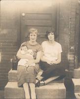 Two women with infant sitting on stoop, Philadelphia.