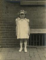 Little girl in summer dress standing on sidewalk, Philadelphia.