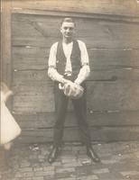 Young man standing in front of board fence, Philadelphia.