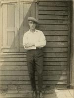 Man leaning against an old wooden wall of a house, Philadelphia.