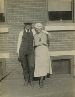Young man and woman standing in front of a brick house, Philadelphia.