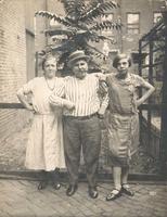Man standing with two women in courtyard, Philadelphia.