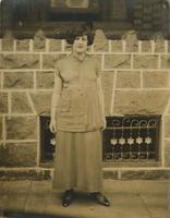 Woman standing in front of brick house with stone porch, Philadelphia.
