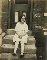Girl sitting on dirty marble steps, Philadelphia.