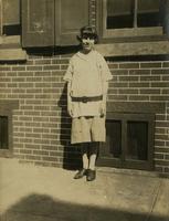Teenage girl standing in front of a brick house, Philadelphia.