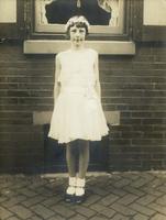 Young girl in white dress standing in front of window, Philadelphia.