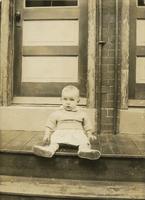 Infant sitting on wooden steps, Philadelphia.