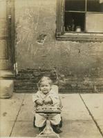 Child sitting in a wheeled scooter, Philadelphia.