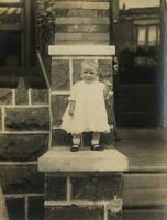 Small child standing on a stone porch, Philadelphia.