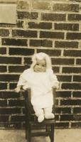 Infant standing in child's chair, Philadelphia.