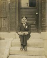 Young man in suit sitting on marble steps, Philadelphia.