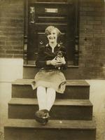 Woman sitting on wooden steps holding a puppy, Philadelphia.