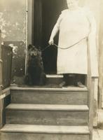 Woman standing on wooden steps with her dog, Philadelphia.