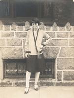 Young woman standing in front of stone wall, Philadelphia.