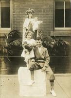 Boy and girl in front of a religious statue of Mary, Philadelphia.