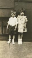 Boy and girl standing in front of brownstone house, Philadelphia.