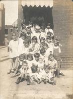Group of children gathered on steps in front of house, Philadelphia.