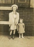 Two girls standing in front of a brick house, Philadelphia.