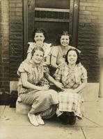 Four young women sitting on marble stoop, Philadelphia.