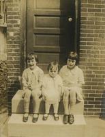 Three little girls sitting on a marble step, Philadelphia.