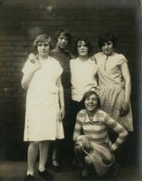 Five young female friends standing in front of a brick wall, Philadelphia.