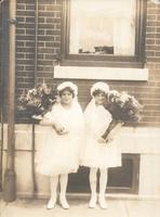 Two girls in First Communion dresses standing in front of window, Philadelphia.