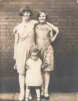 Three girls standing in front of brick wall, Philadelphia.