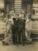 Four teenage boys standing in front of brick and stone house, Philadelphia.