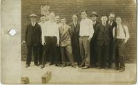 Eleven men standing in front of brick wall, Philadelphia.